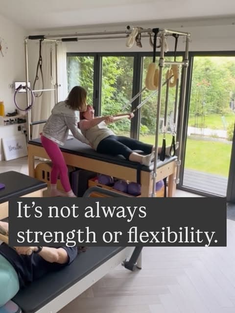 Ali assisting arm springs on the Cadillac with a second client on the reformer